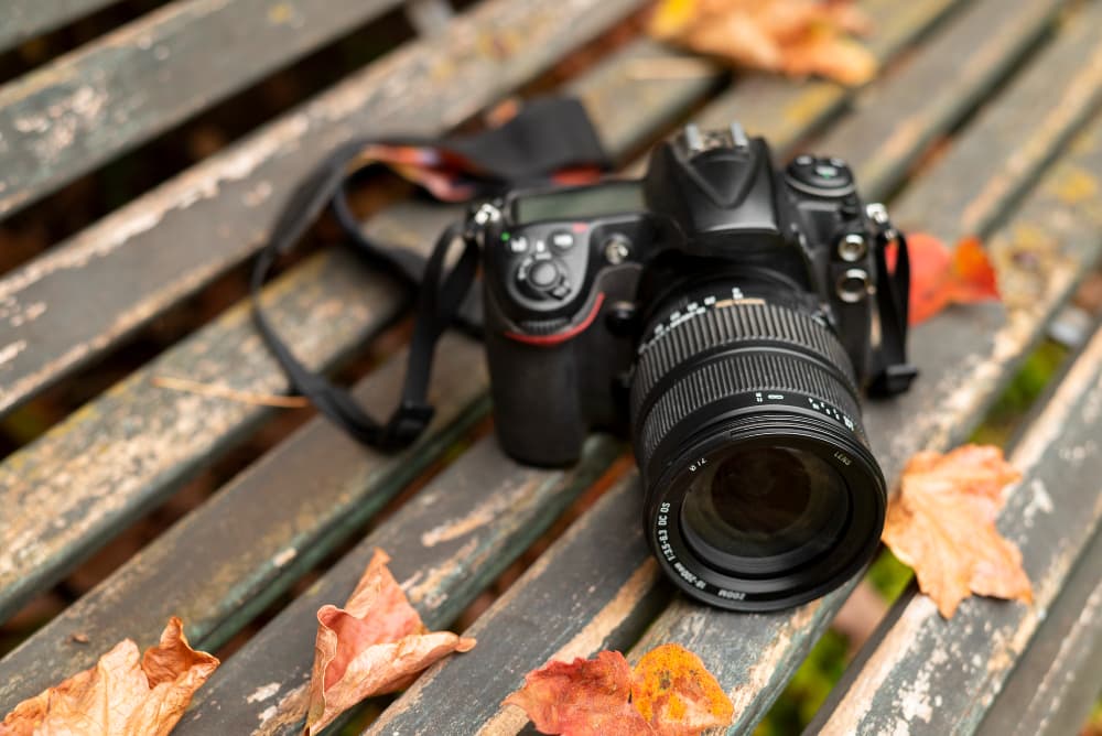 Les mains d'un homme tenant un "appareil photo" reflex numérique avec un objectif, prêt à capturer une image
