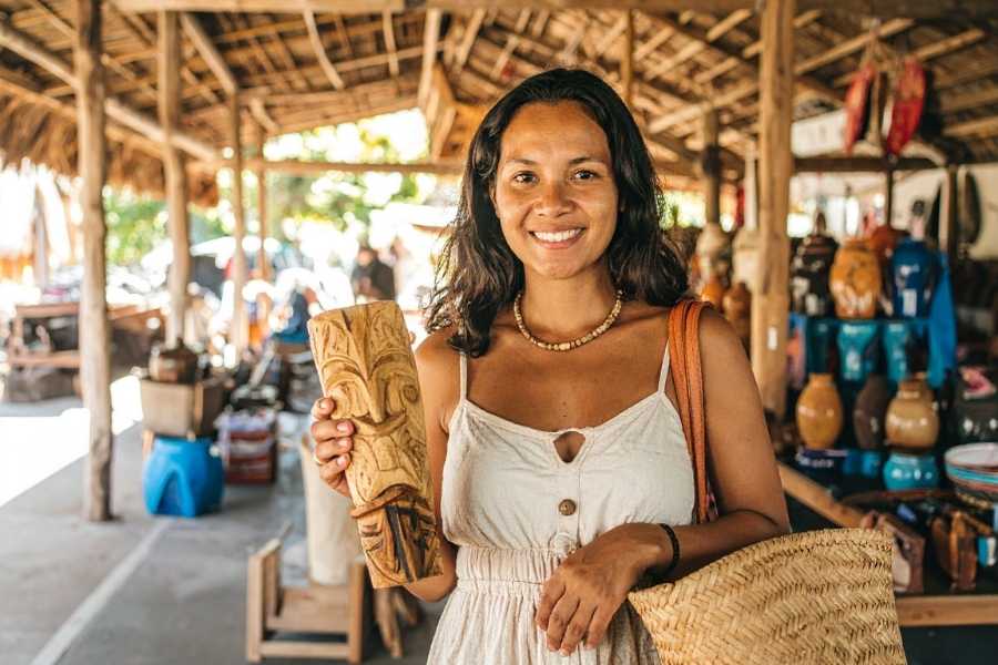 Femme souriante présentant sculpture en bois dans boutique d'artisanat local