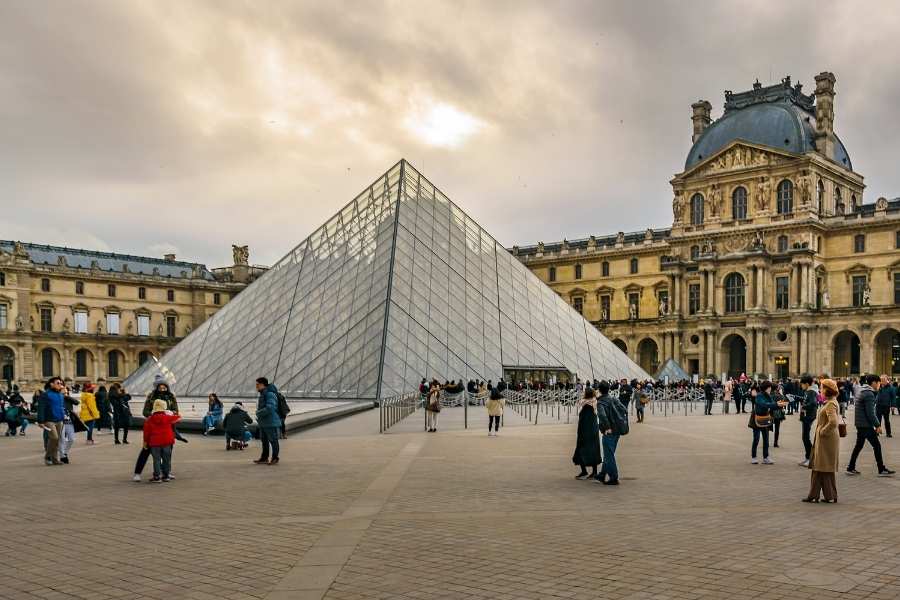 Pyramide du Louvre avec visiteurs dans la cour, l'un des musées gratuits à Paris certains jours