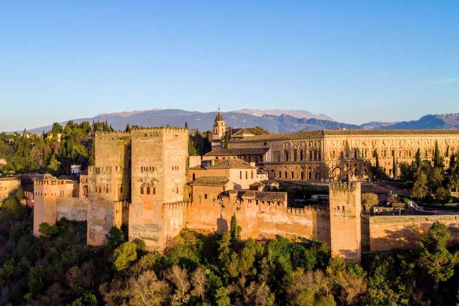 L’Alhambra de Grenade, joyau du patrimoine UNESCO en Espagne Palais de l'Alhambra à Grenade illuminé par le soleil couchant avec montagnes de la Sierra Nevada