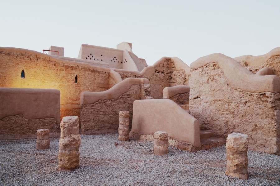 Village traditionnel en pisé avec architecture en terre crue et ruines anciennes