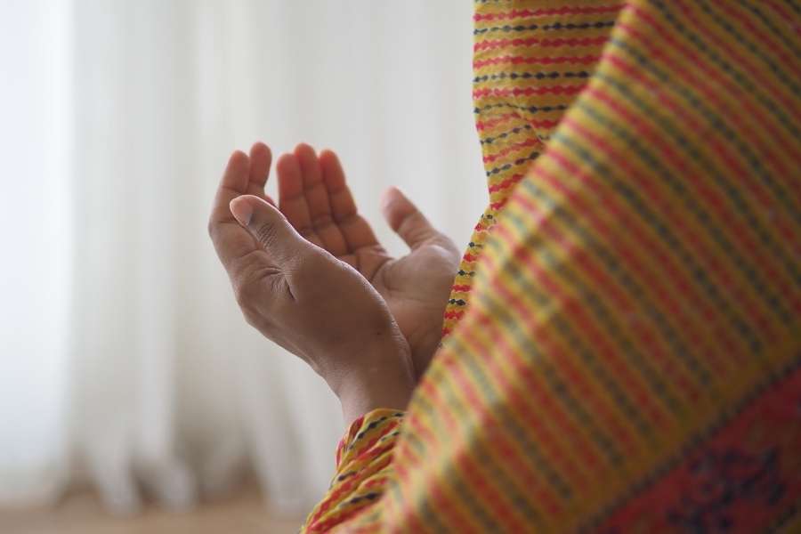 Rituels de prière et recueillement spirituel Mains ouvertes en position de prière avec châle coloré traditionnel