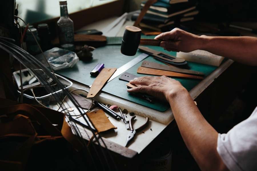Renaissance de l’artisanat du cuir et savoir-faire manuel Artisan travaillant le cuir dans son atelier avec outils traditionnels