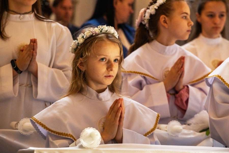 Jeunes filles en robes blanches priant lors d'une cérémonie religieuse