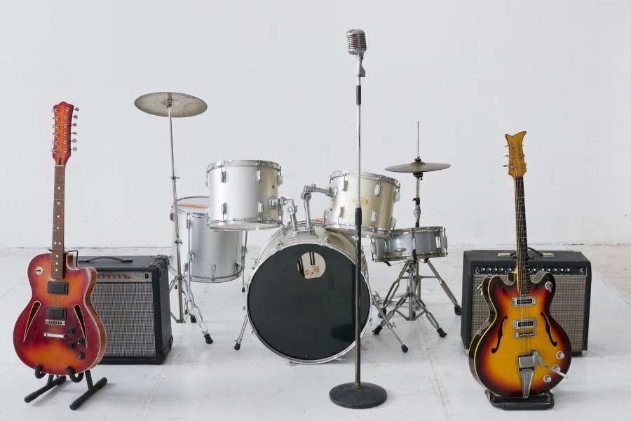 Configuration complète de groupe de rock avec guitares, batterie, amplificateurs et microphone vintage