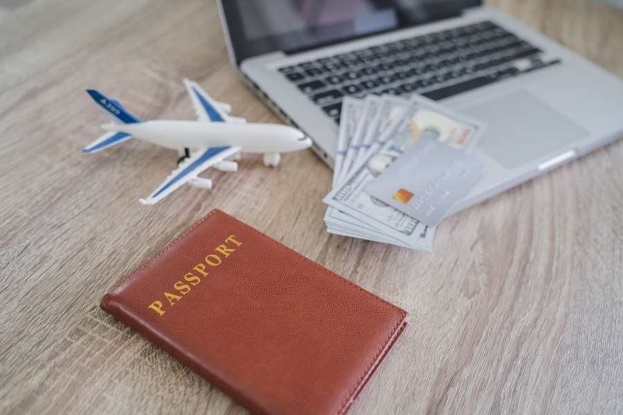 Un passeport, une maquette d'avion et de l'argent disposés pour la préparation de billets d'avion.